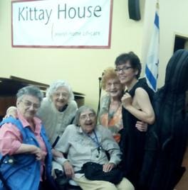 A group of people posing for a picture in front of a sign.
