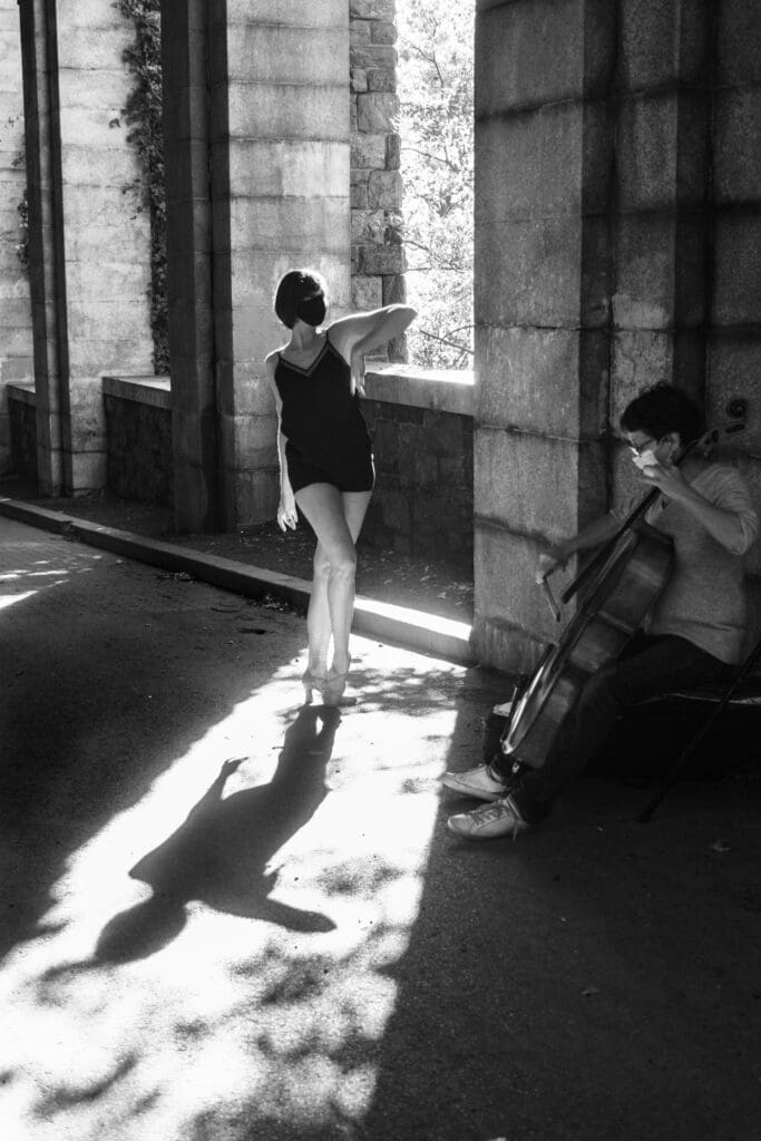 A woman walking down the street while holding her violin.